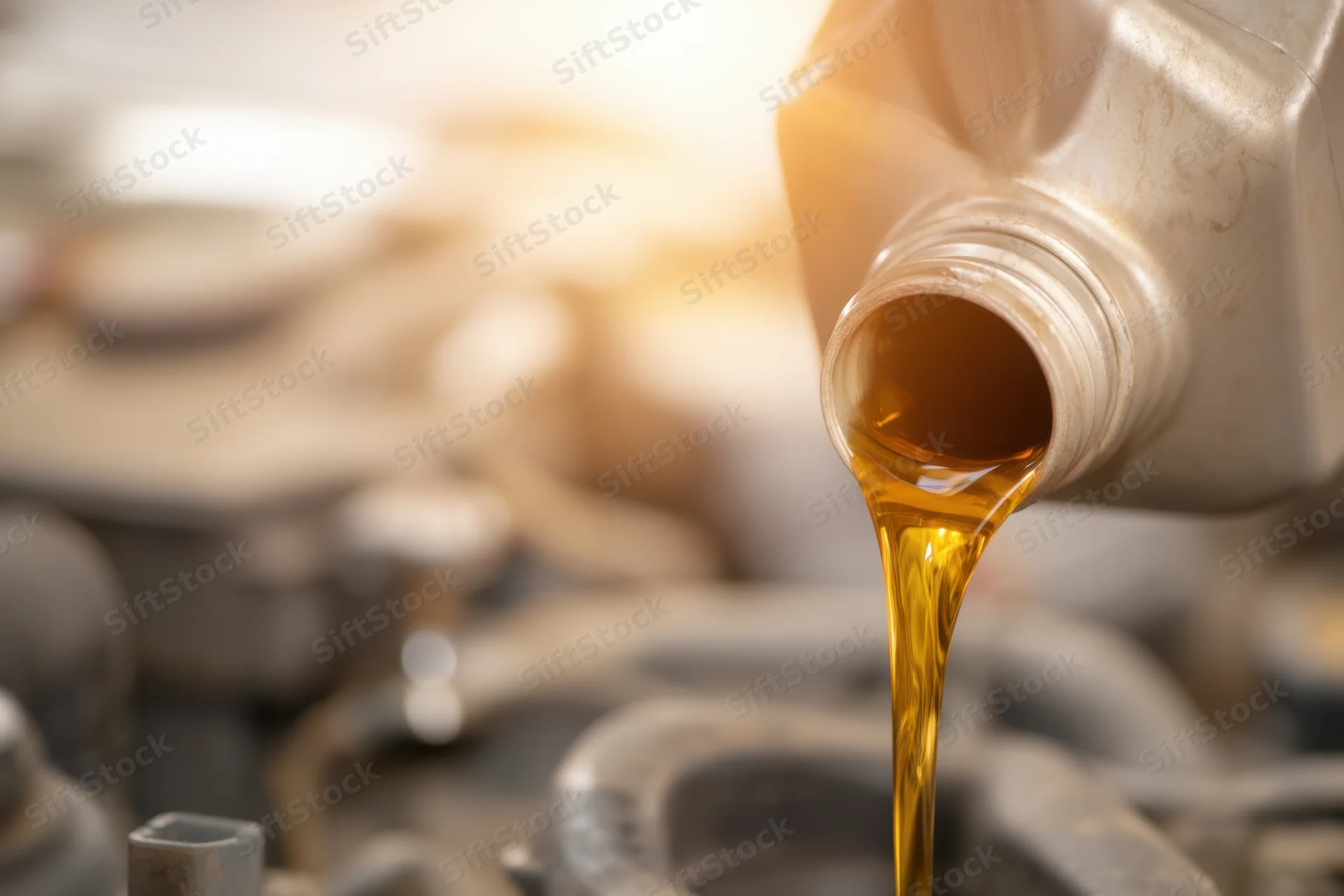 Motor oil being poured from a bottle into an engine during maintenance