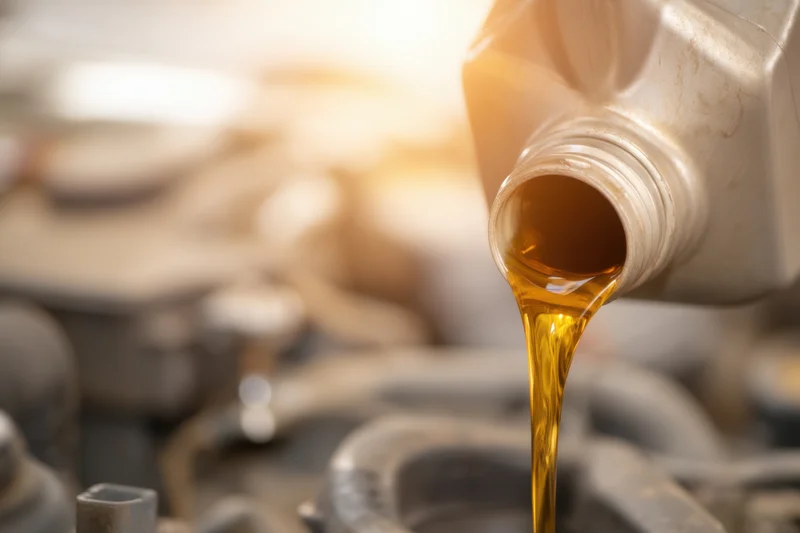 Motor oil being poured from a bottle into an engine during maintenance