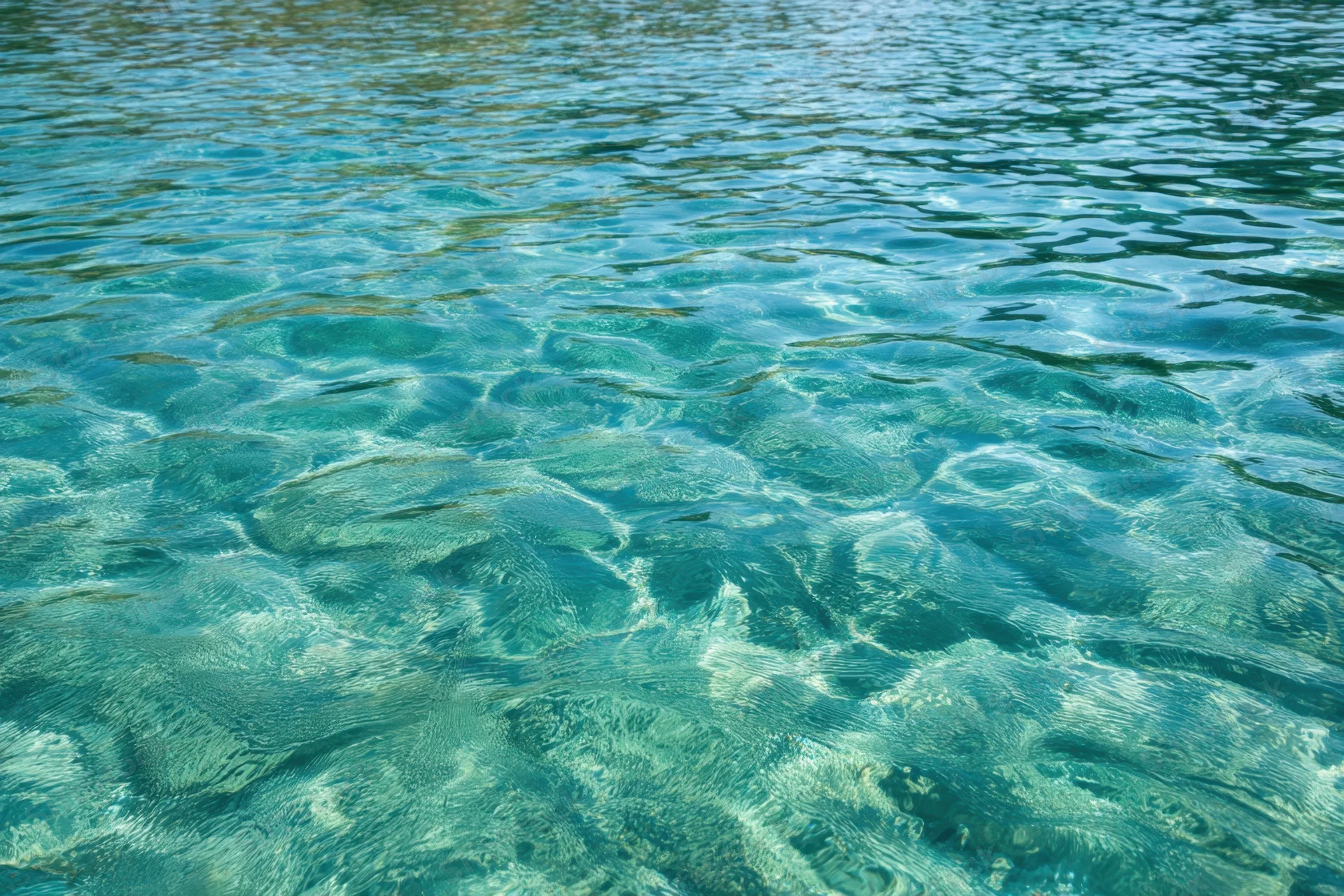 Turquoise water with gentle ripples and reflections on a calm surface