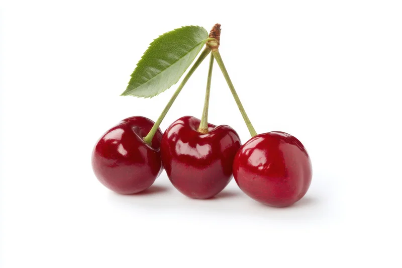 Three shiny red cherries with green stems and a leaf arranged on a white background