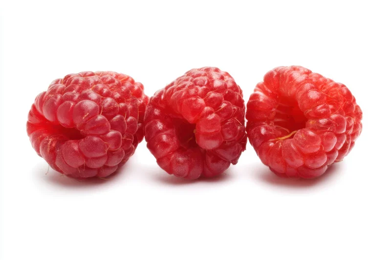 Three fresh raspberries arranged in a line on a white background