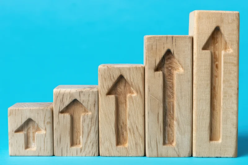 Wooden blocks with carved arrows arranged in ascending order on a blue background