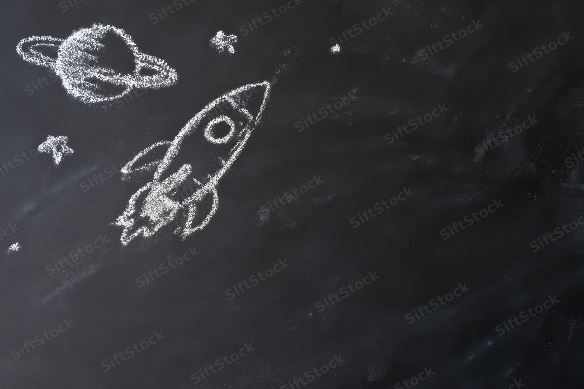 Chalk drawing of a rocket ship flying through space with planets and stars on a blackboard