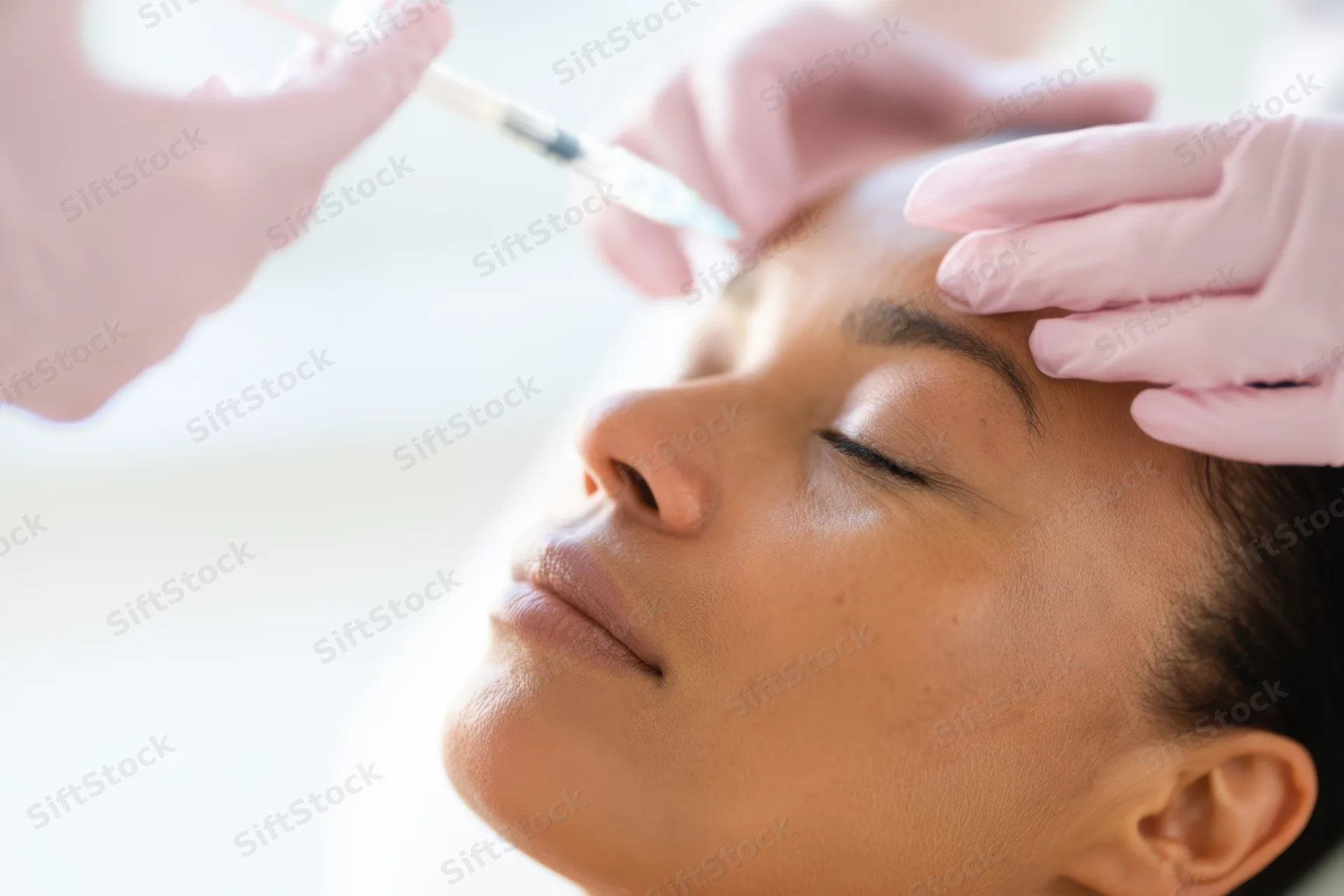Woman receiving botox injection on forehead in medical spa setting