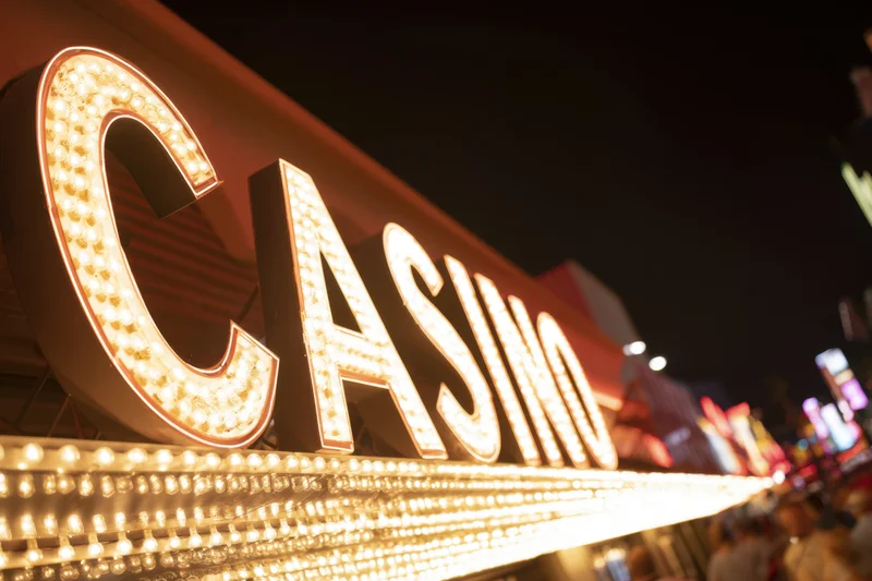 Brightly illuminated casino sign with bold letters at night on a city street