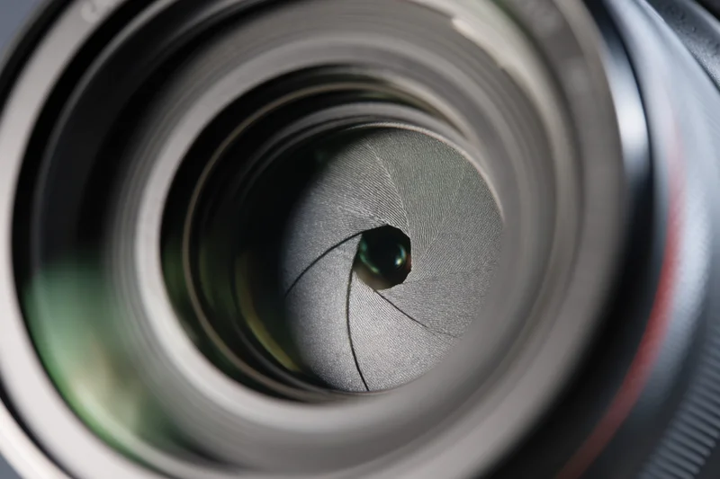 Closeup of camera lens aperture with visible blades arranged in a circular pattern