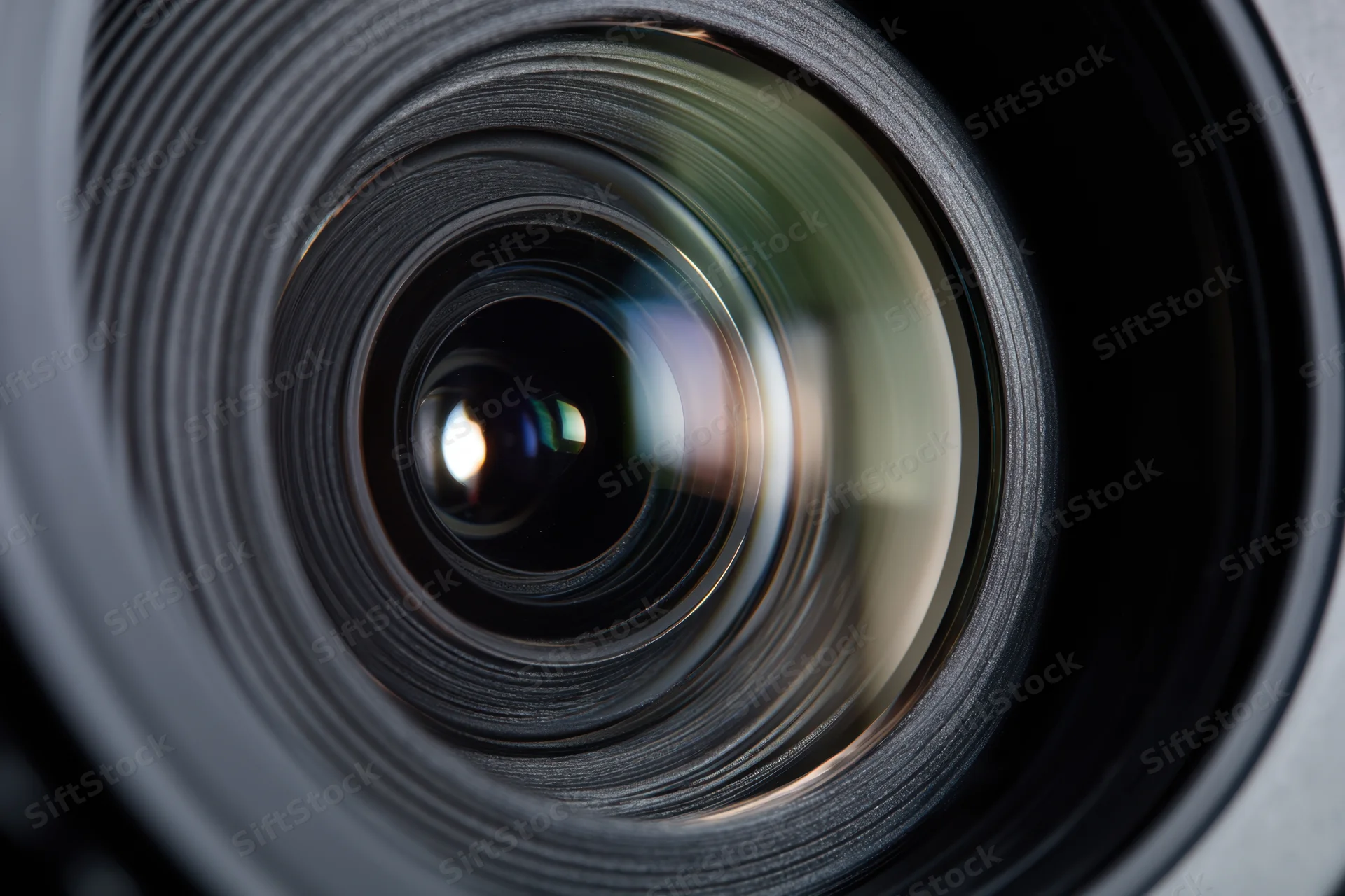 Closeup of a camera lens showing intricate glass elements and reflective surfaces in a detailed view