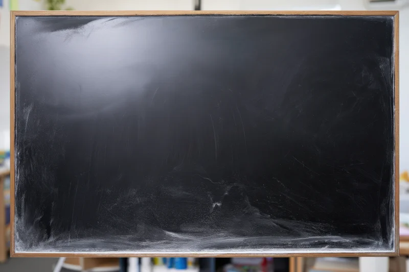 Smooth dark black chalkboard with white residue and smudges in a classroom setting