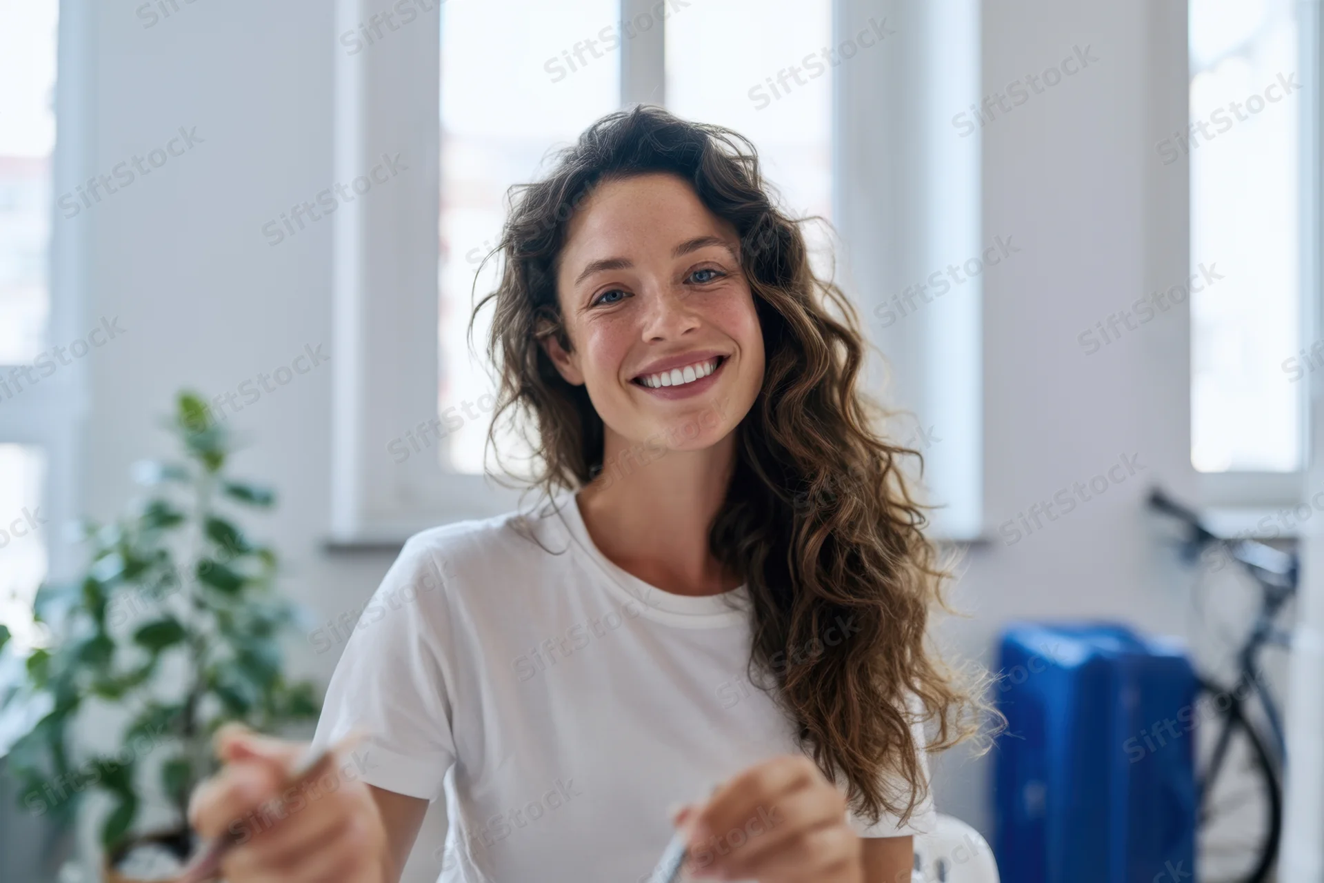 Cheerful young woman smiling at camera in bright office workspace