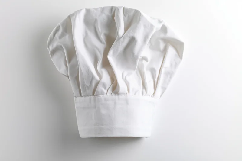 White chef hat with soft fabric and gathered crown on plain background