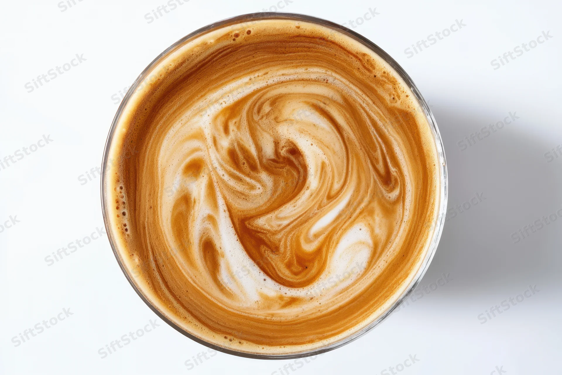 Creamy coffee surface with swirling foam pattern in a glass cup viewed from above