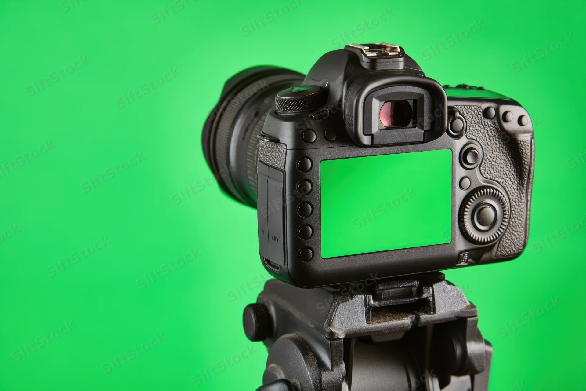 Professional dslr camera mounted on tripod with green screen display against green background