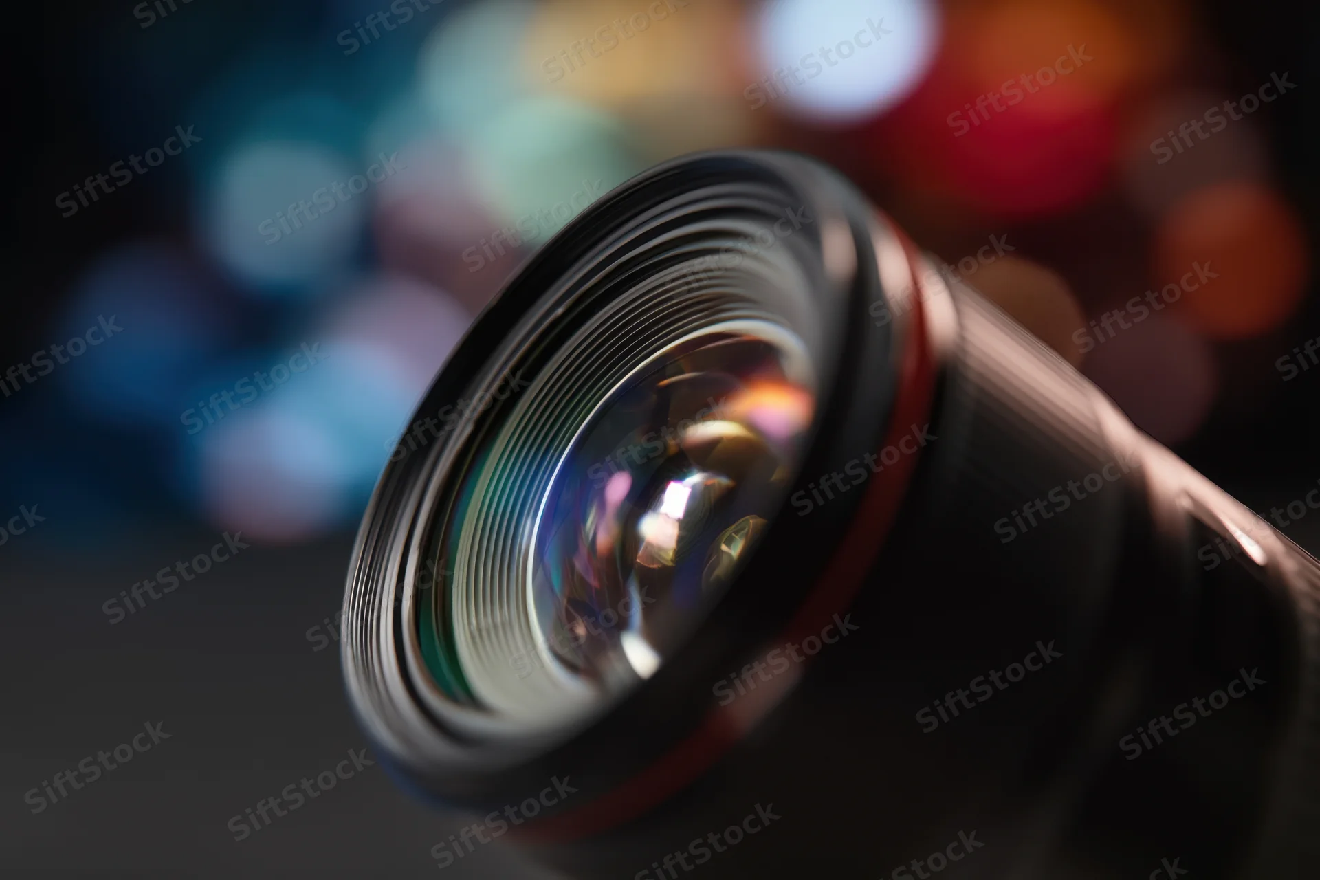 Closeup of a professional camera lens with intricate glass structure against a blurred bokeh background