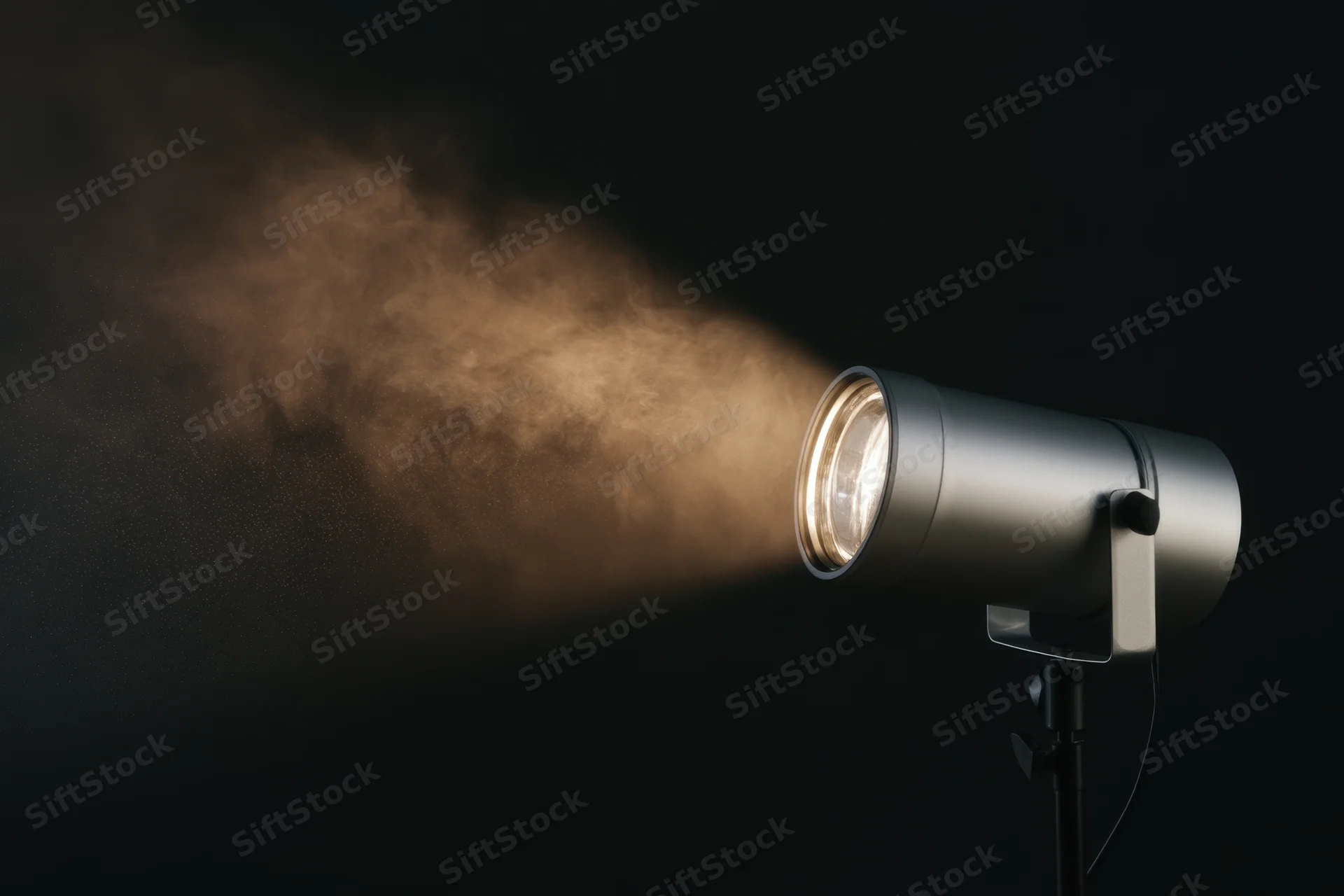 Professional studio spotlight emitting a warm beam of light through smoke against a dark background