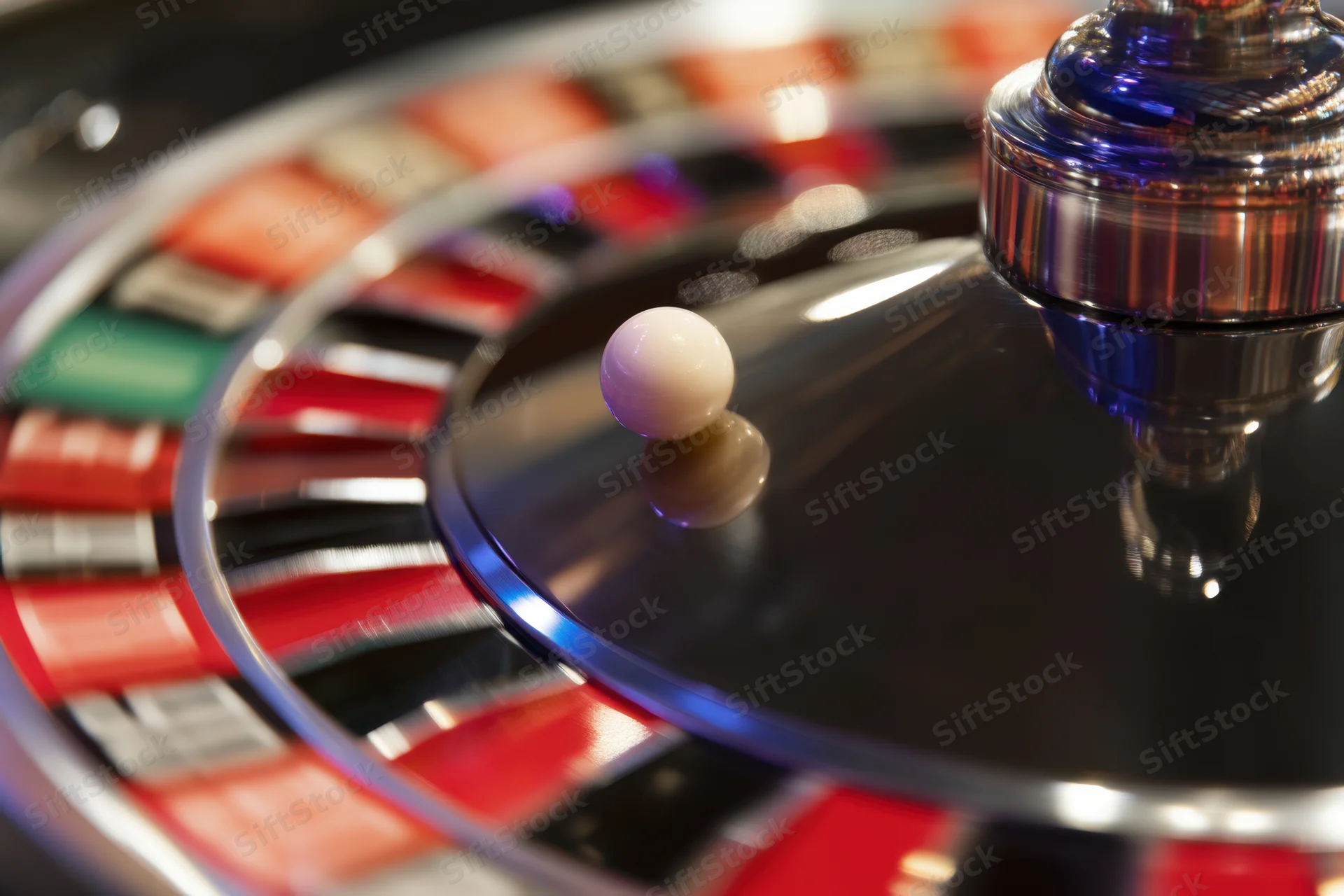 Spinning roulette wheel with white ball and metallic spinner in casino setting