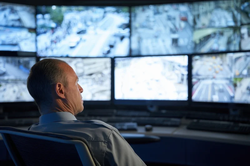 Security operator monitoring multiple video feeds in a control room