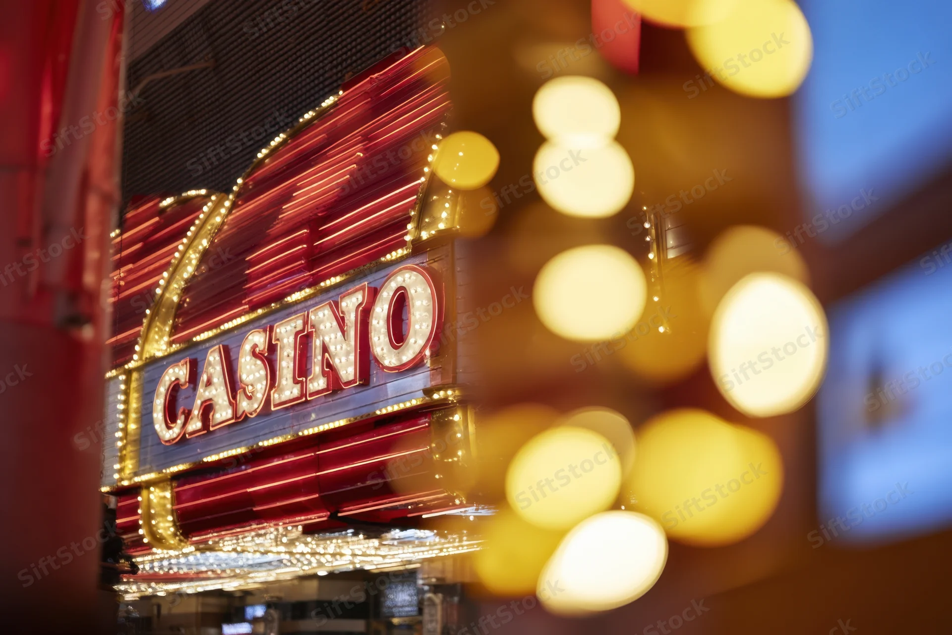 Illuminated casino entrance with neon sign and blurred lights at night