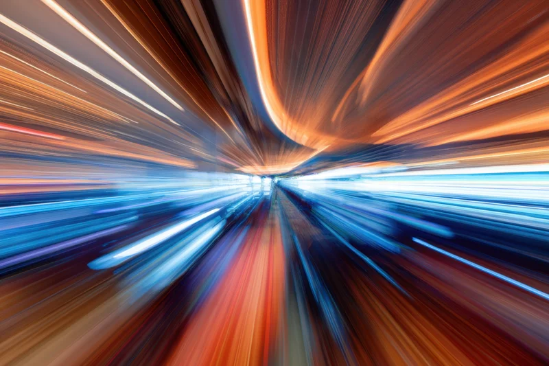 Blurred neon lights streaking through a casino tunnel at night