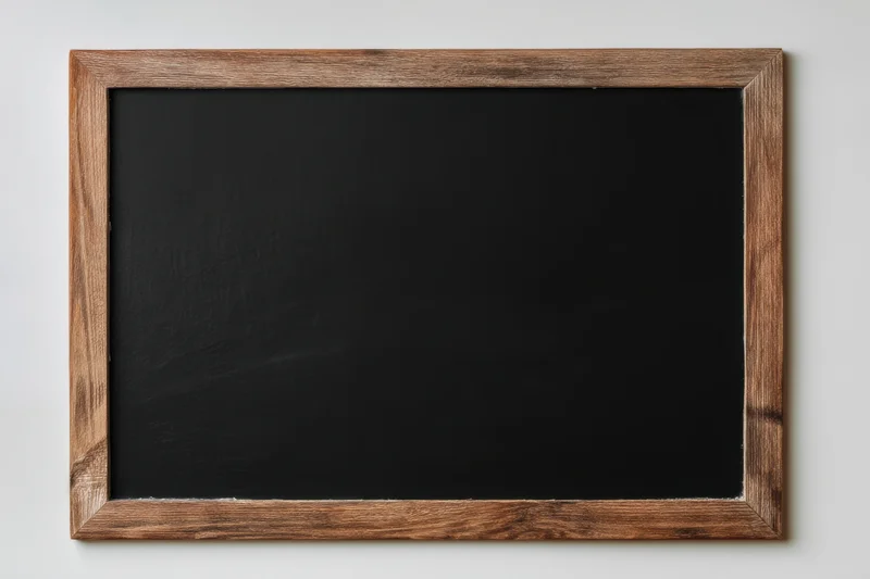 Vintage black chalkboard with distressed wooden frame mounted on a white wall