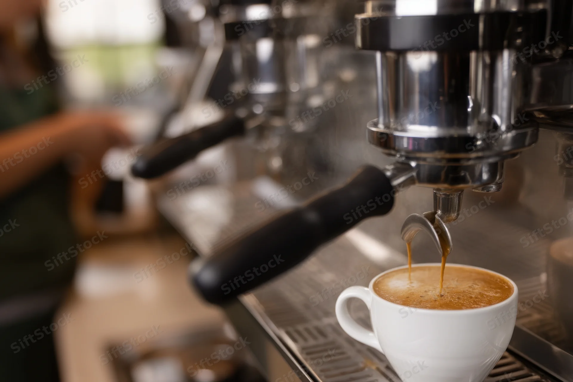 Espresso machine dispensing coffee into a white cup on a commercial counter