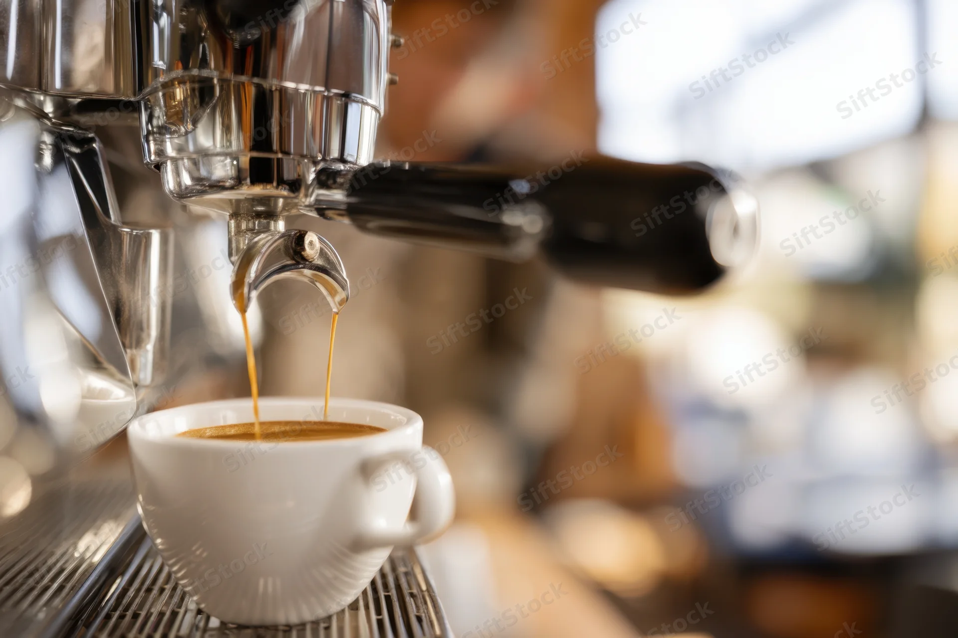 Espresso machine dispensing coffee into a white cup on a metal drip tray in a cafe