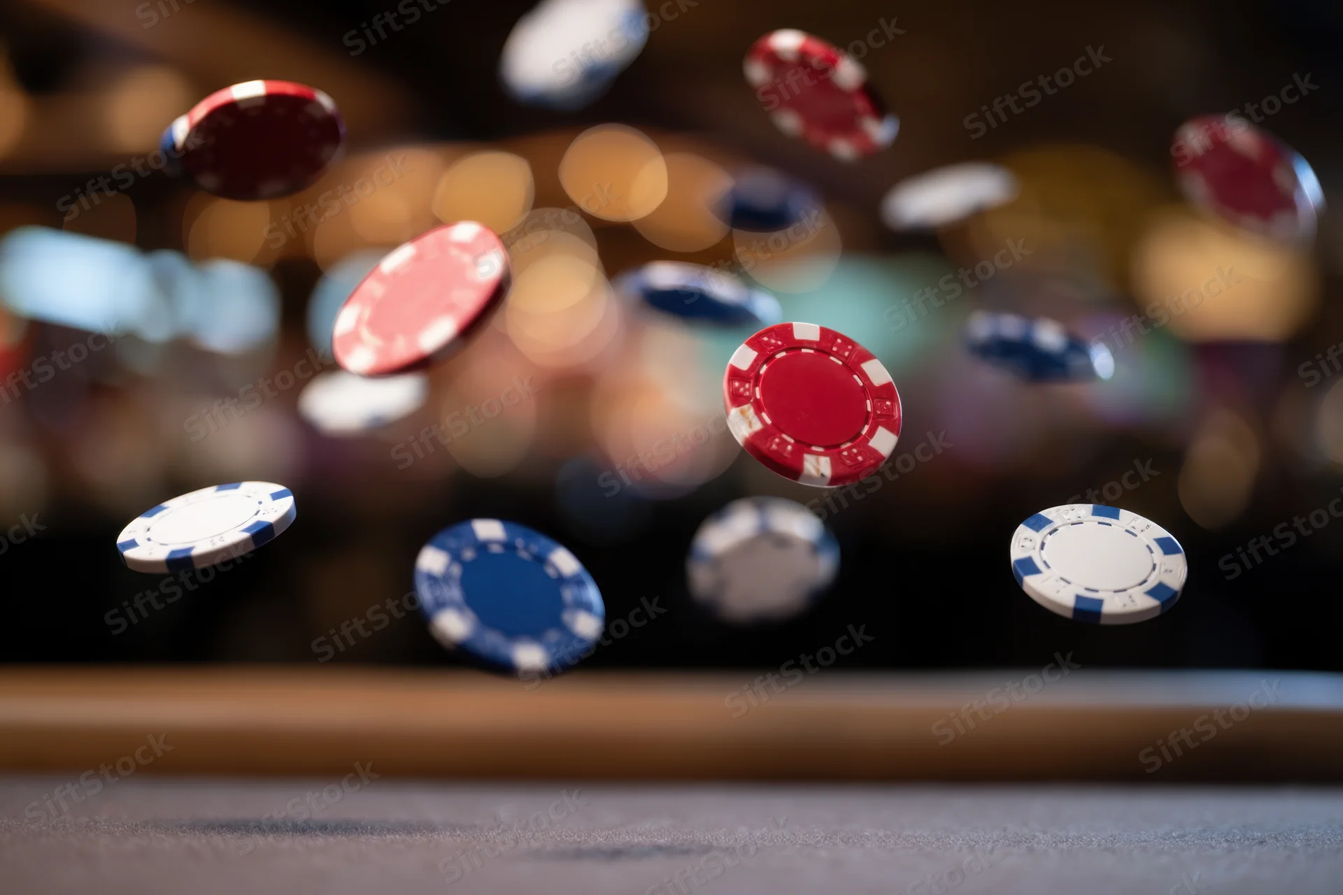 Poker chips falling in midair over a casino table with blurred bokeh lights in the background