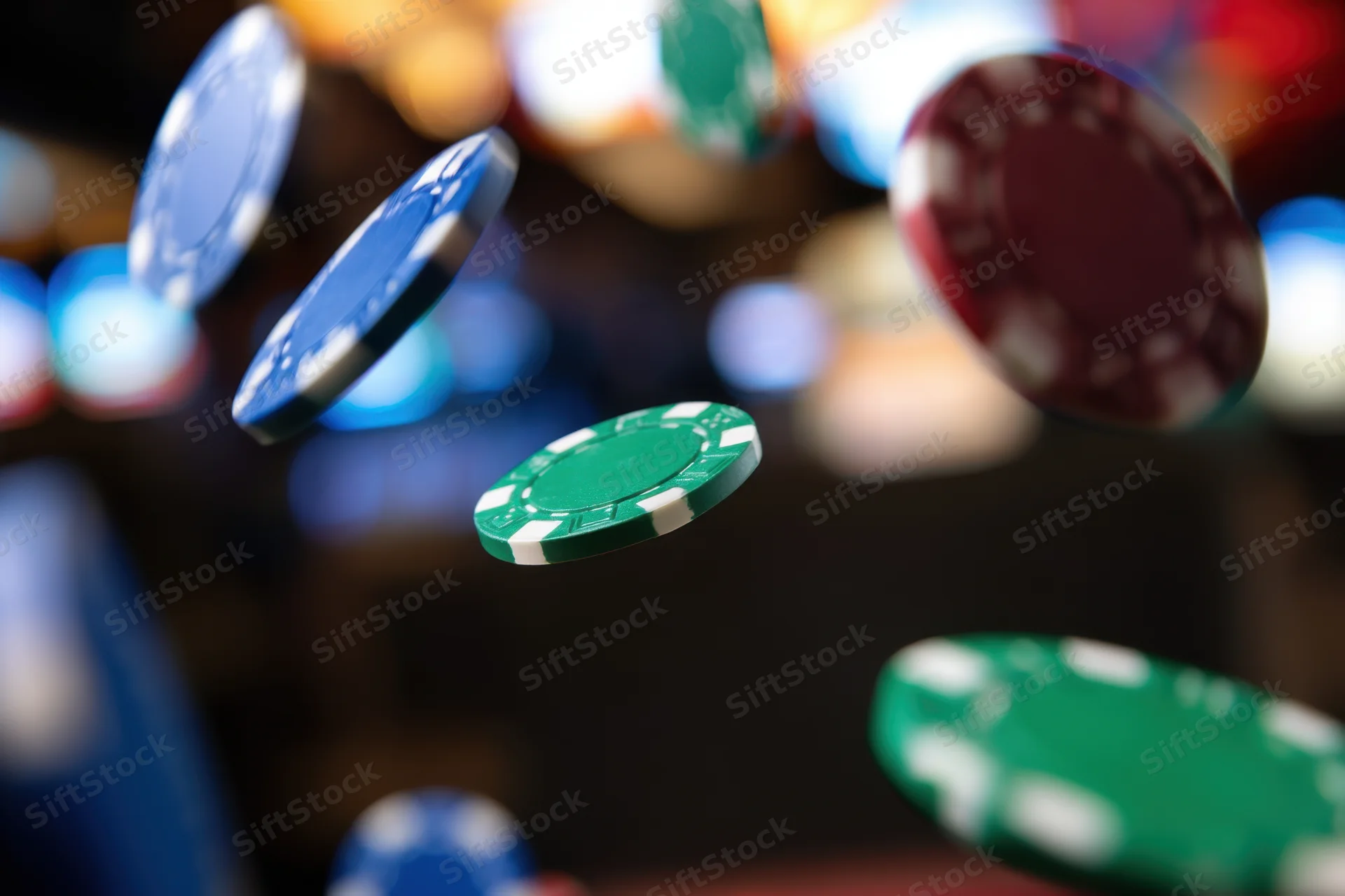 Poker chips flying in midair against a blurred casino background with bokeh lights