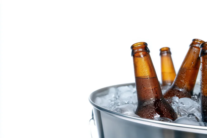Amber beer bottles chilled in ice inside a metal bucket