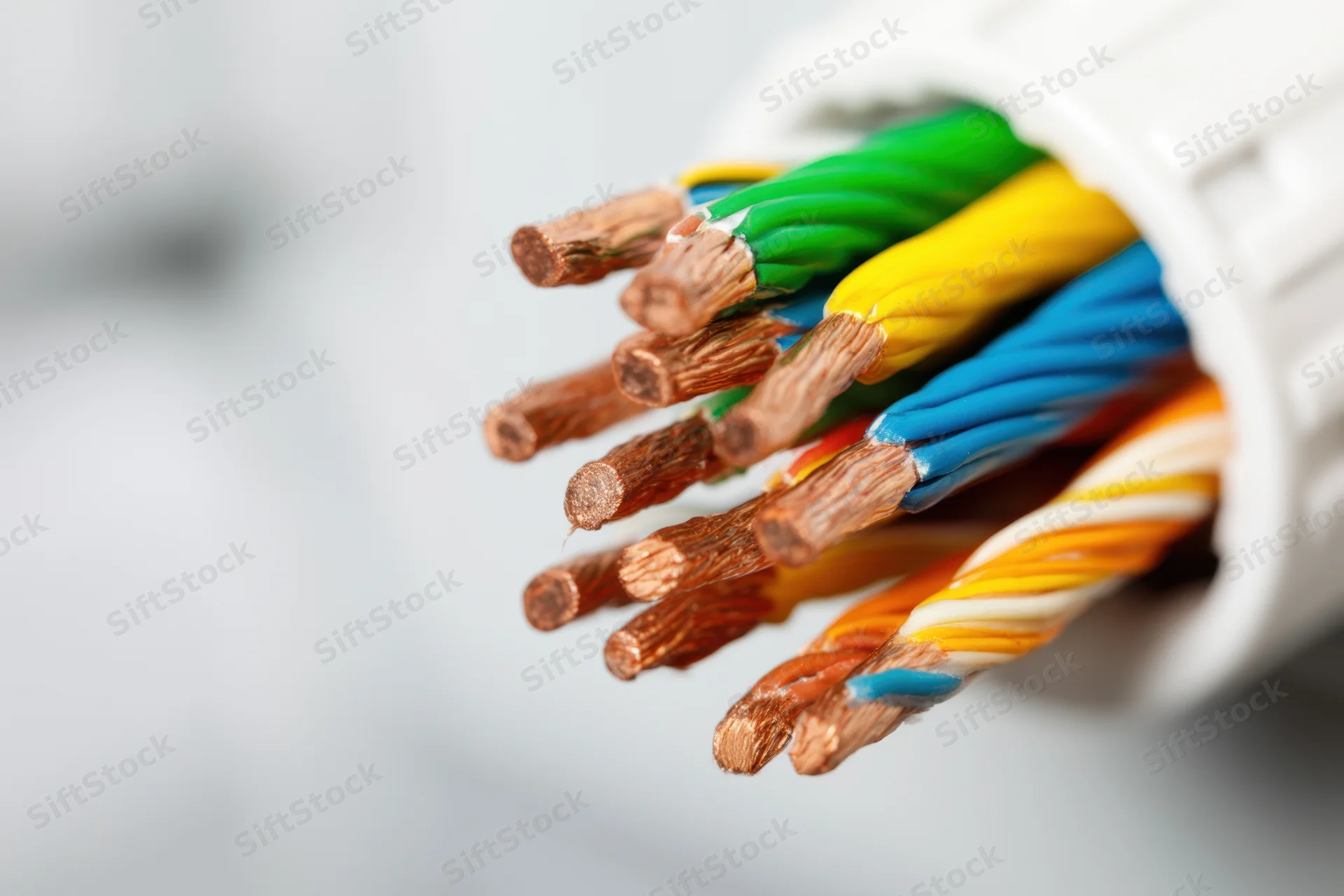 Close-up of multicolored ethernet cable wires with exposed copper cores emerging from white connector