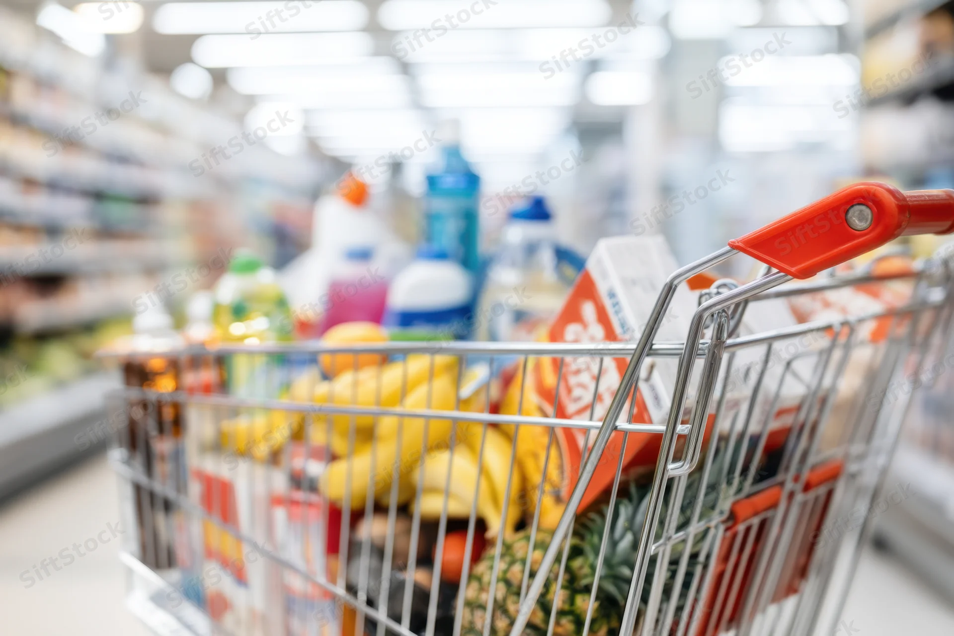 Shopping cart filled with groceries in a supermarket aisle