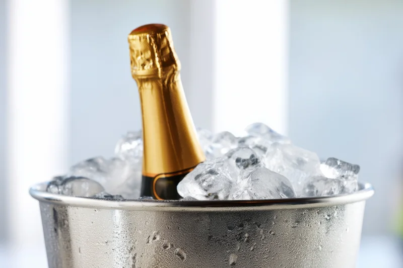 Champagne bottle in ice bucket with condensation, ready for celebration