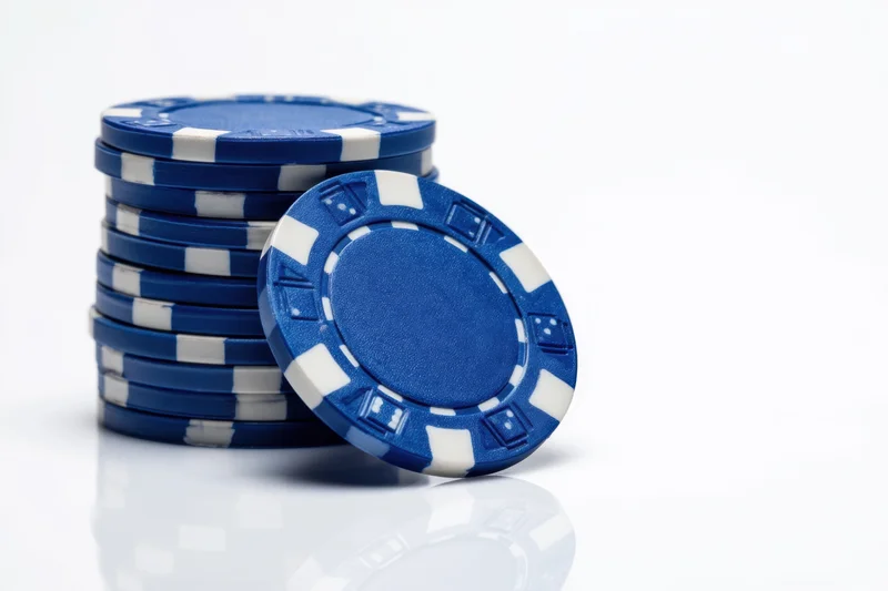 Stack of blue poker chips with white stripes on white background