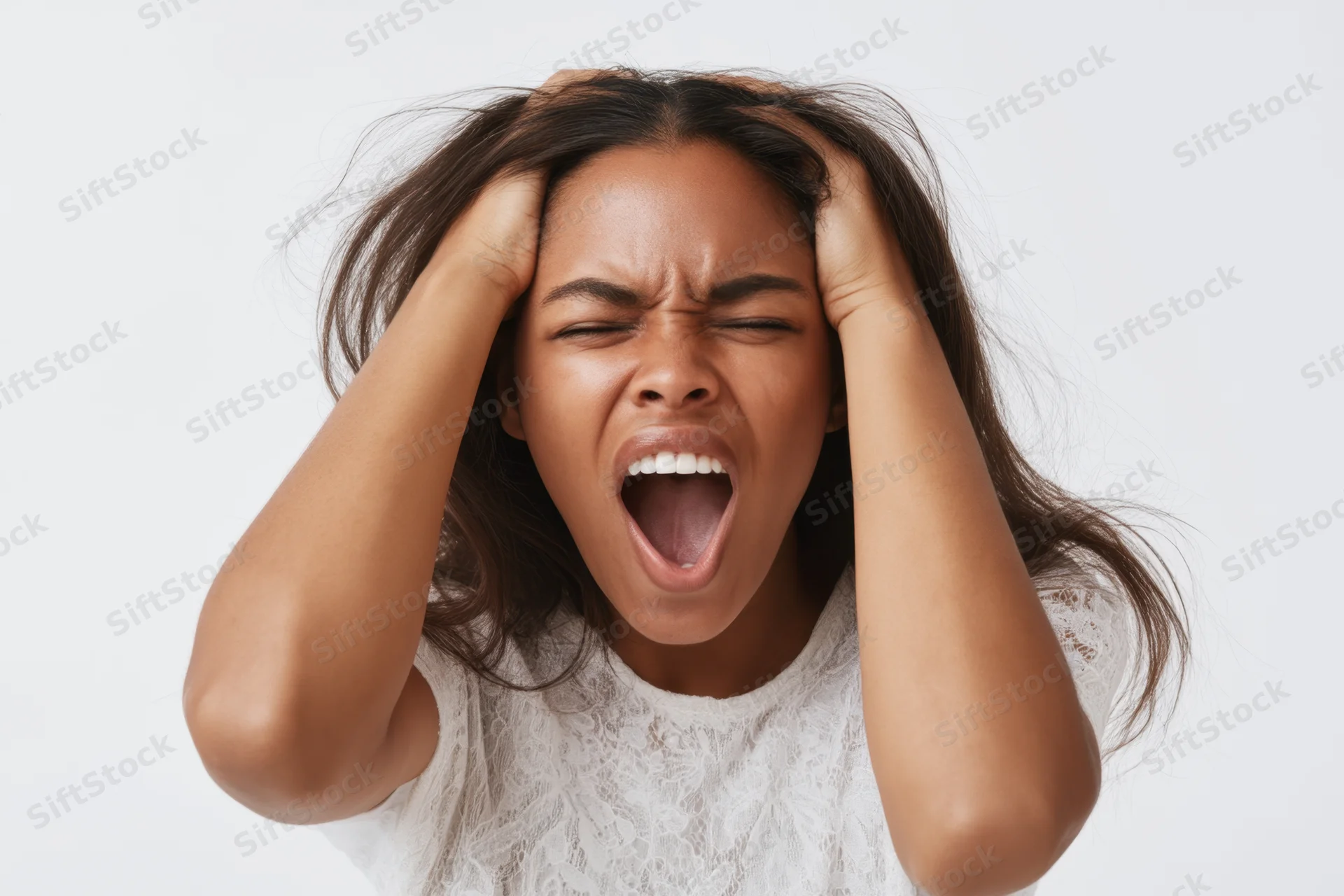 Young black woman screaming with hands in her hair in studio portrait