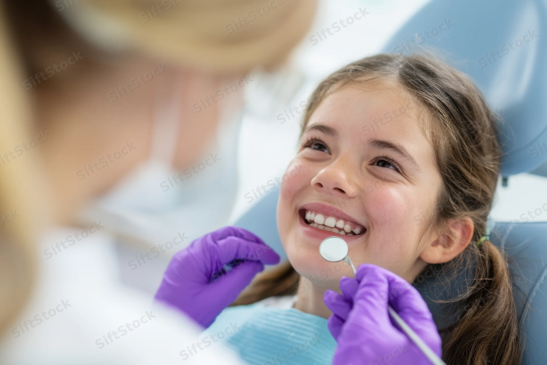 Young girl smiling during dental examination in a clinic chair