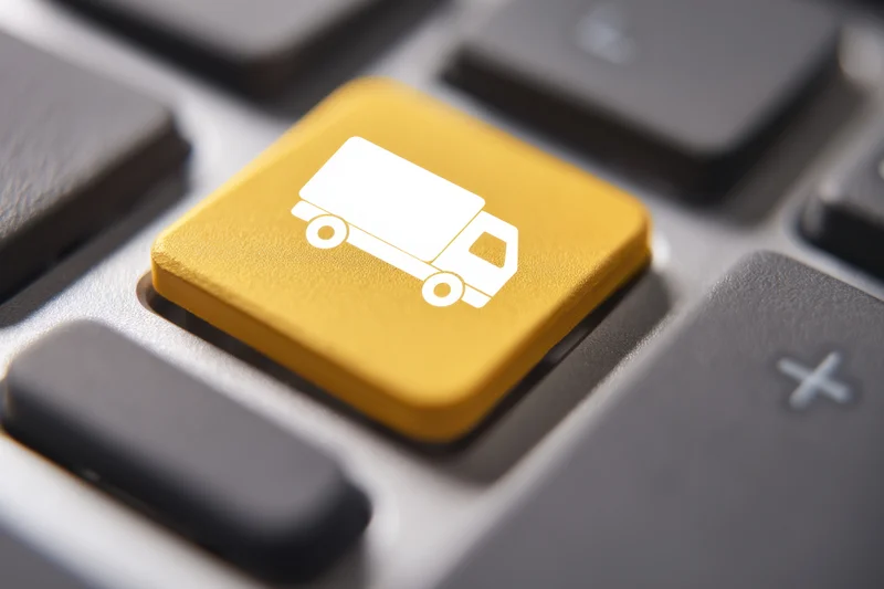 Close-up of a gold keyboard key with a white truck icon among standard keys