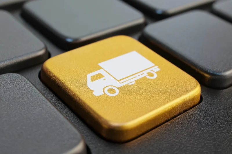 Golden keyboard key with white truck icon among black keys