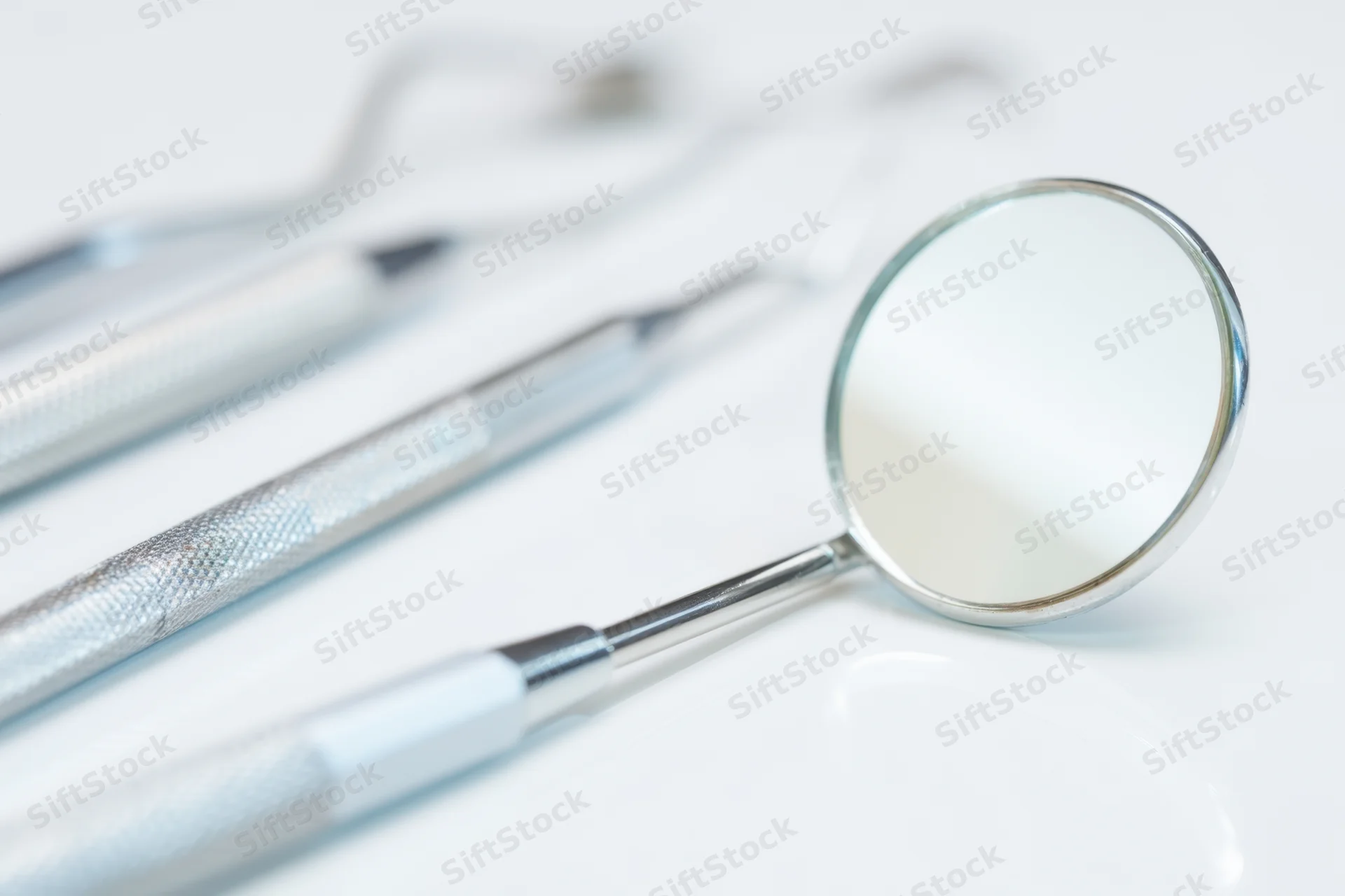 Dental mirror and instruments on white surface
