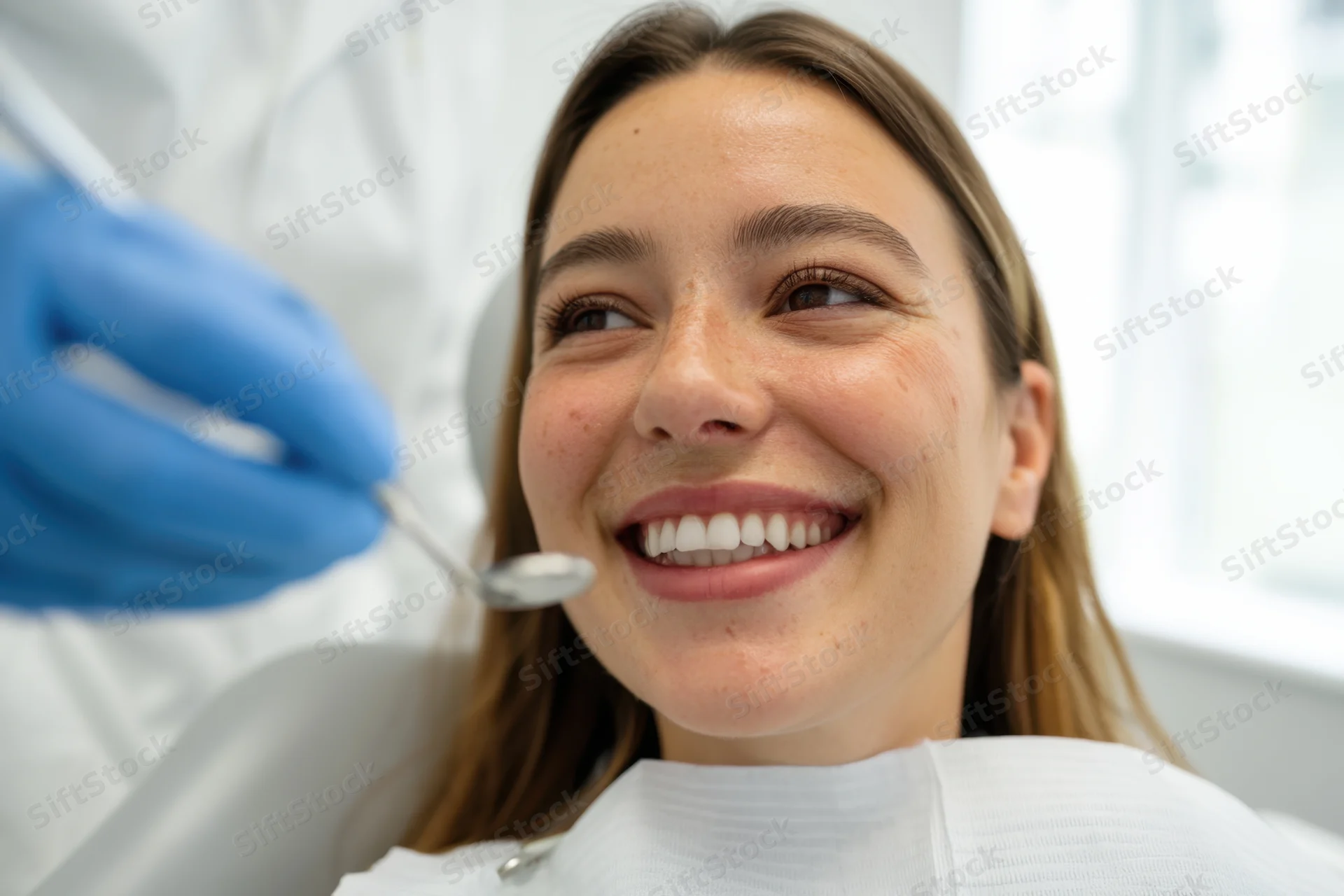 Smiling woman reclining in dental chair during examination