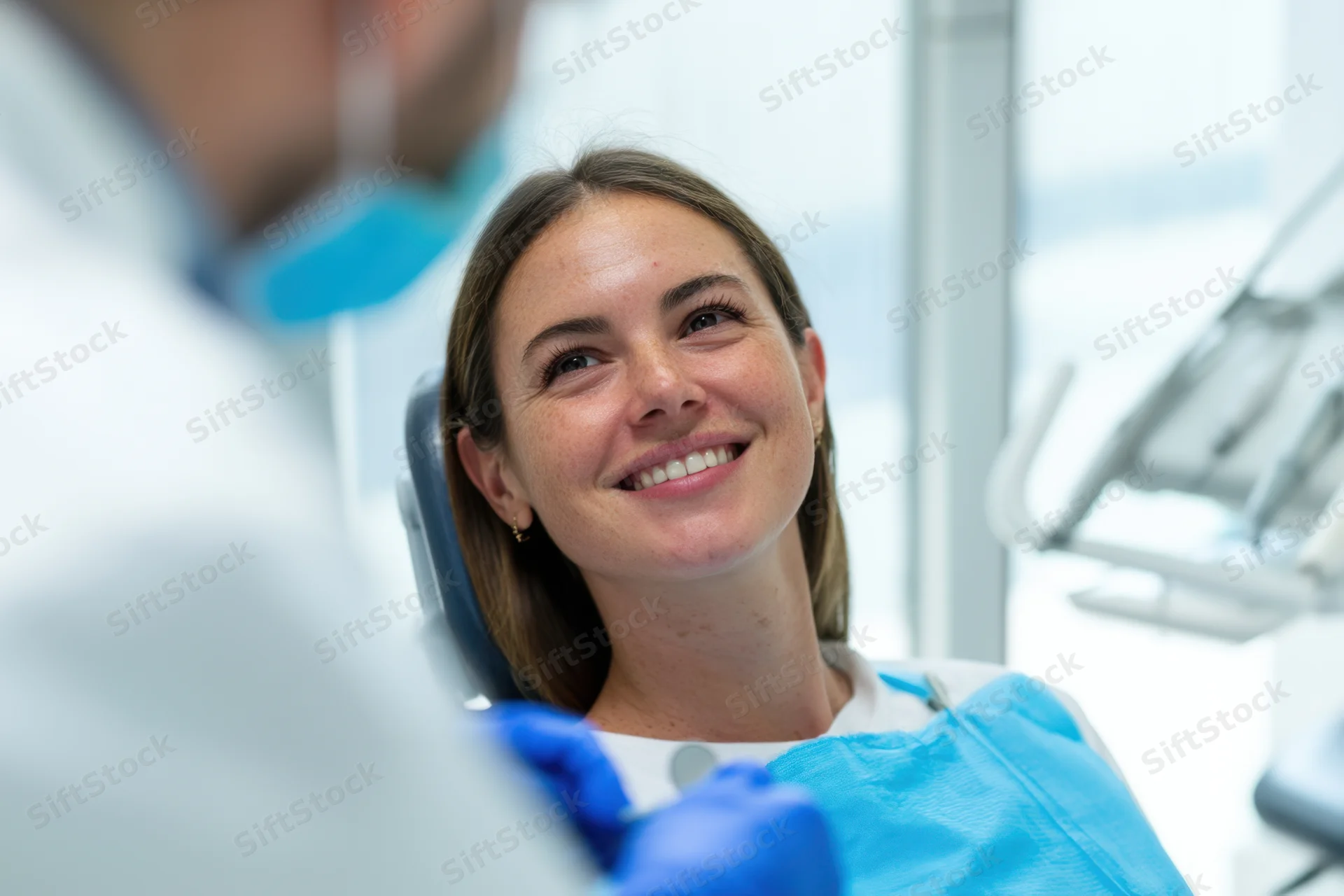 Woman patient smiling in dental chair during examination