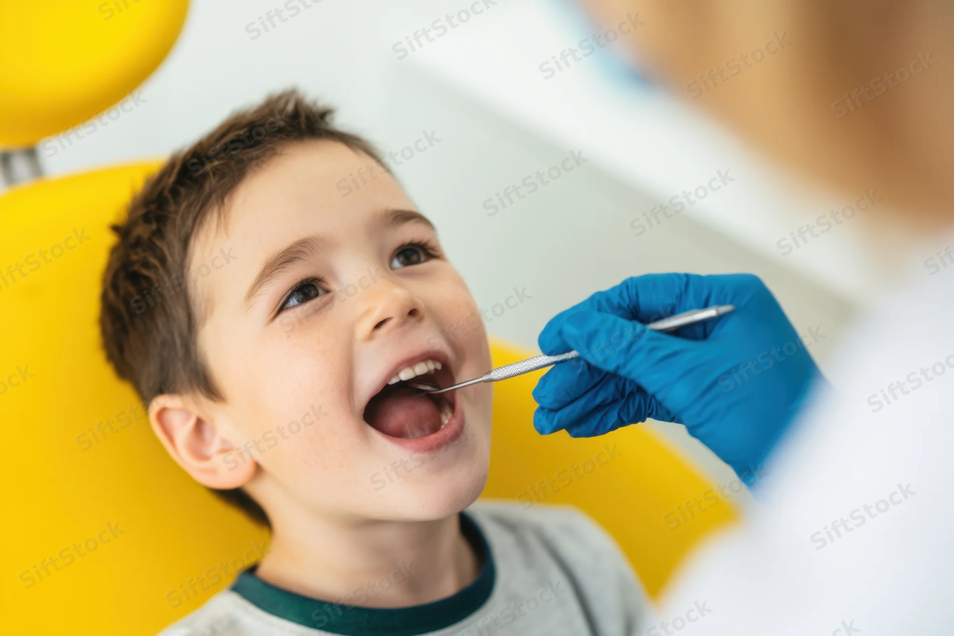 Young boy smiling during dental examination in a clinic chair