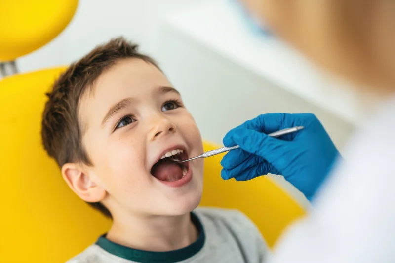 Young boy smiling during dental examination in a clinic chair