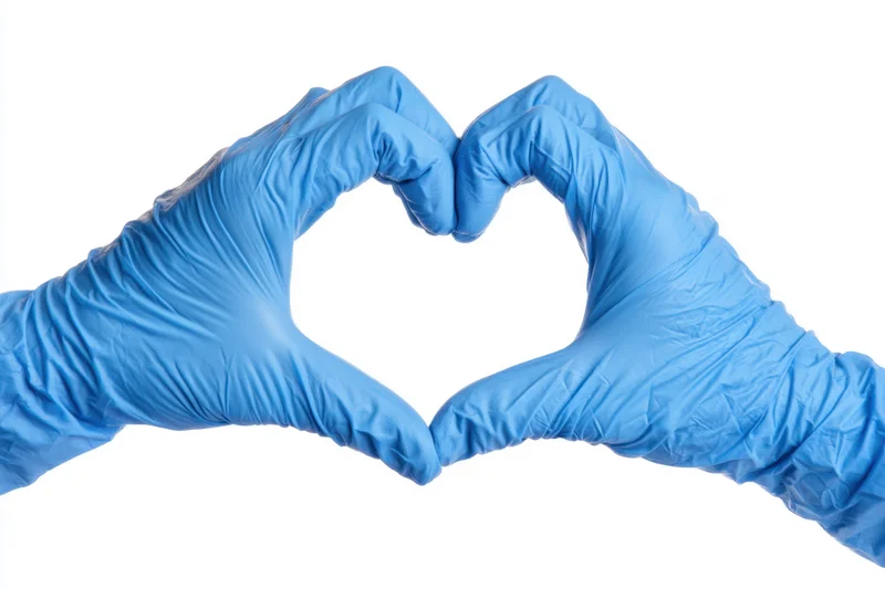 Hands in blue nitrile gloves forming a heart shape against white background