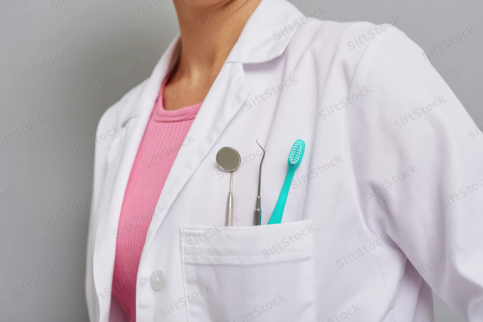 Woman in white labcoat with dental tools in pocket