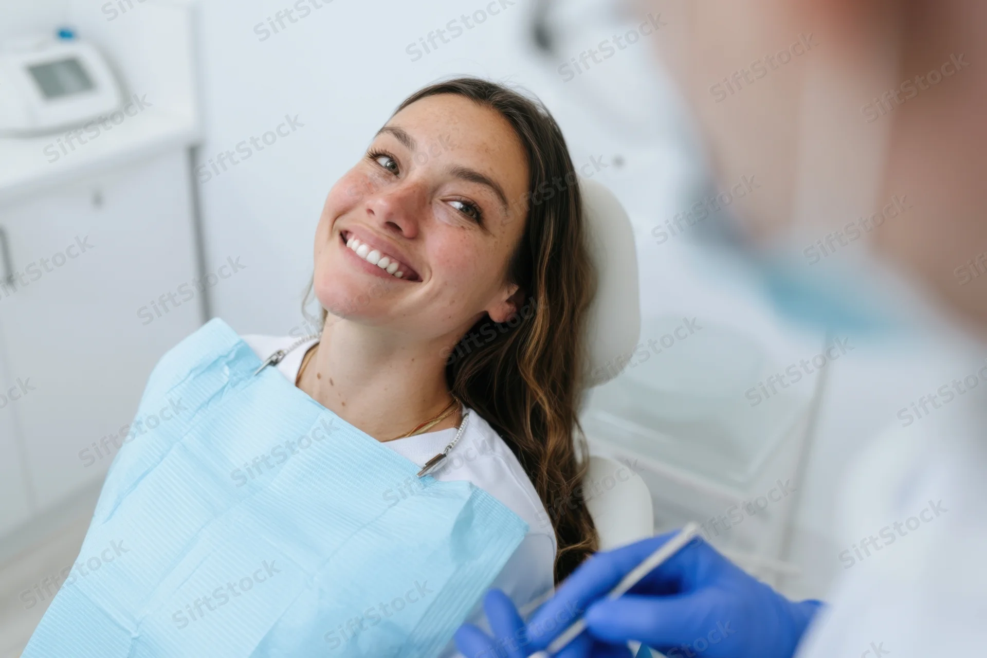 Woman smiling in dental chair during examination by dentist