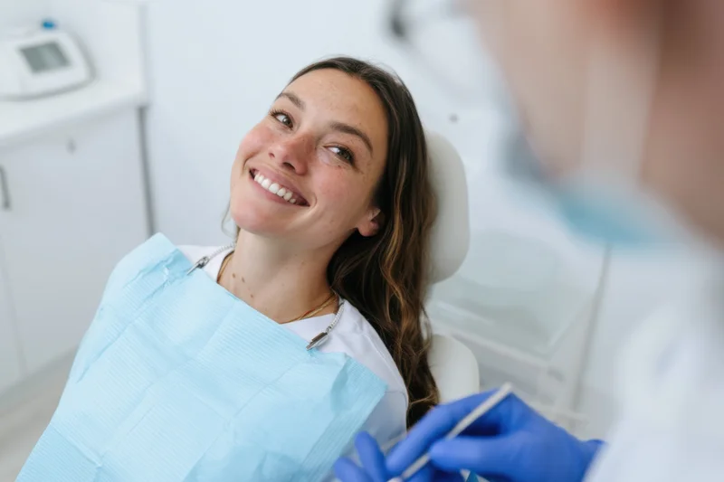 Woman smiling in dental chair during examination by dentist