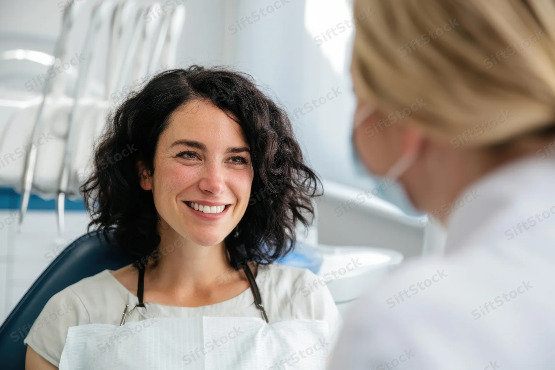 Woman patient smiling in dental chair during examination