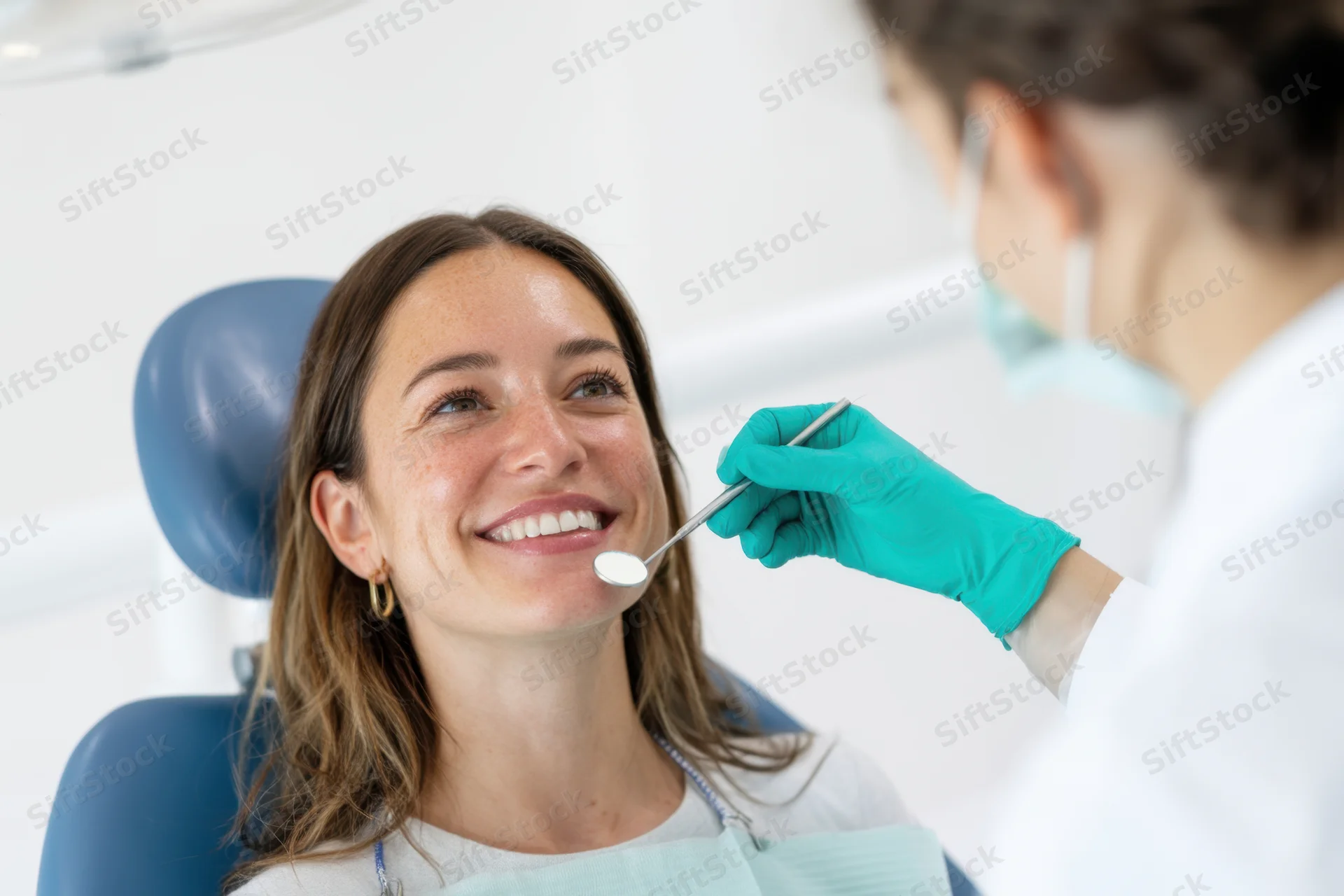 Woman smiling during dental examination in clinic chair