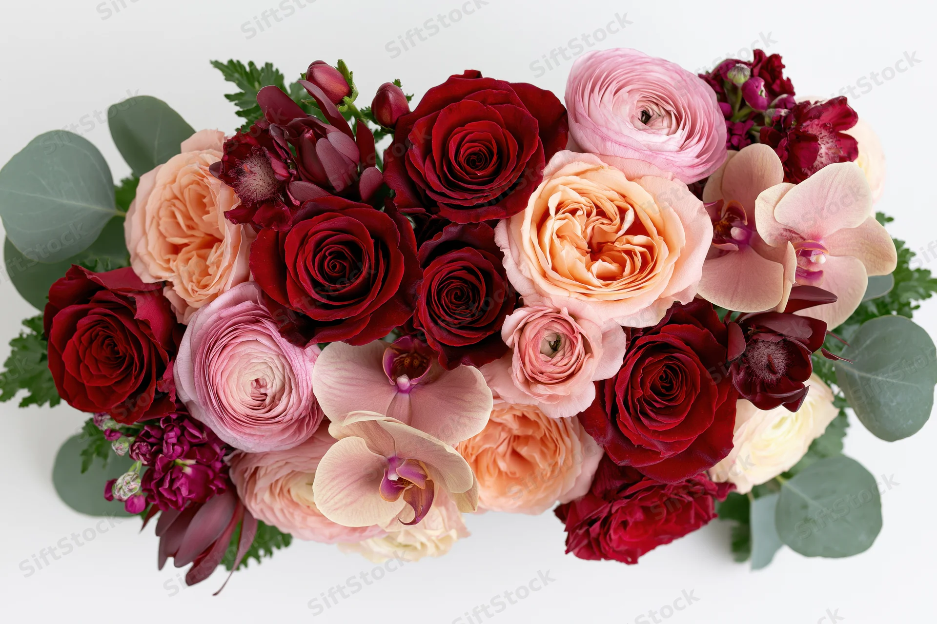 Horizontal mixed flower bouquet with roses, peonies, orchids and greenery on white background