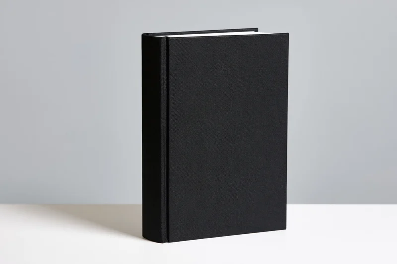 Black hardcover book standing upright on white surface