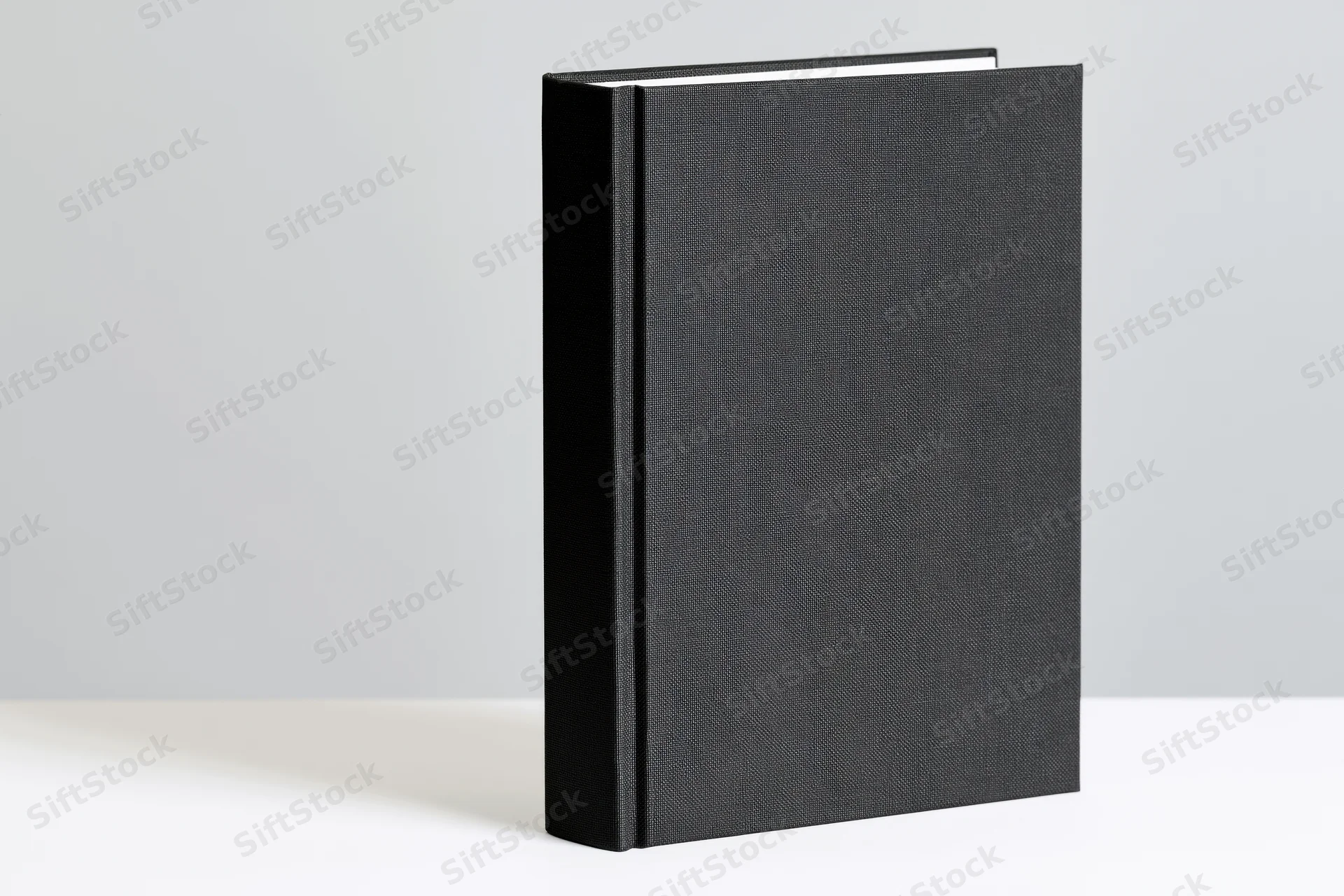 Black hardcover book standing upright on white surface